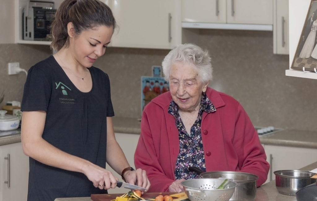 Focus Care support worker cooking with senior client