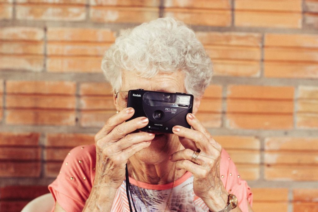 Older lady with camera. Activity for people living with dementia - Focus Care