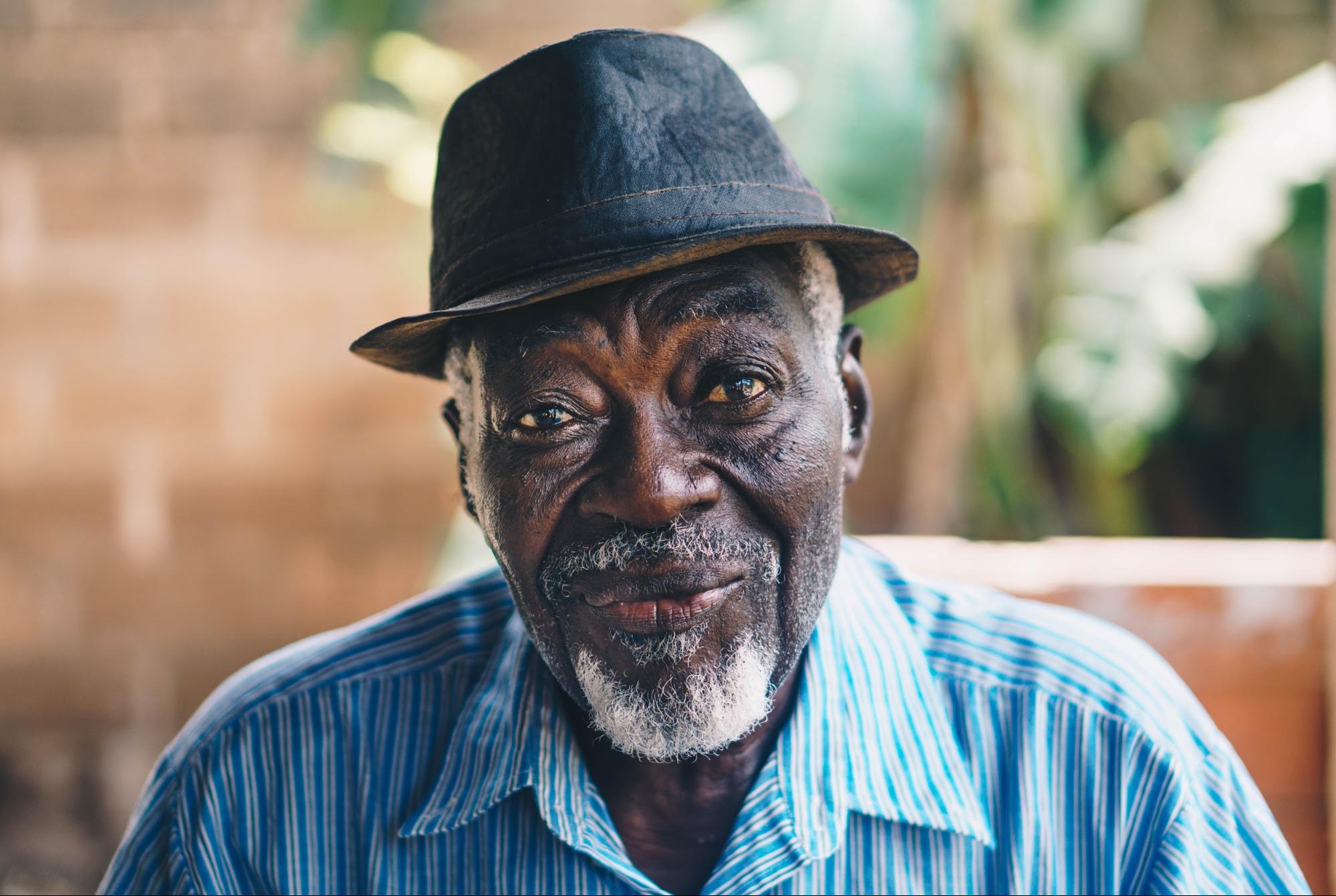 Older gentleman in a hat sitting outdoors - Focus Care