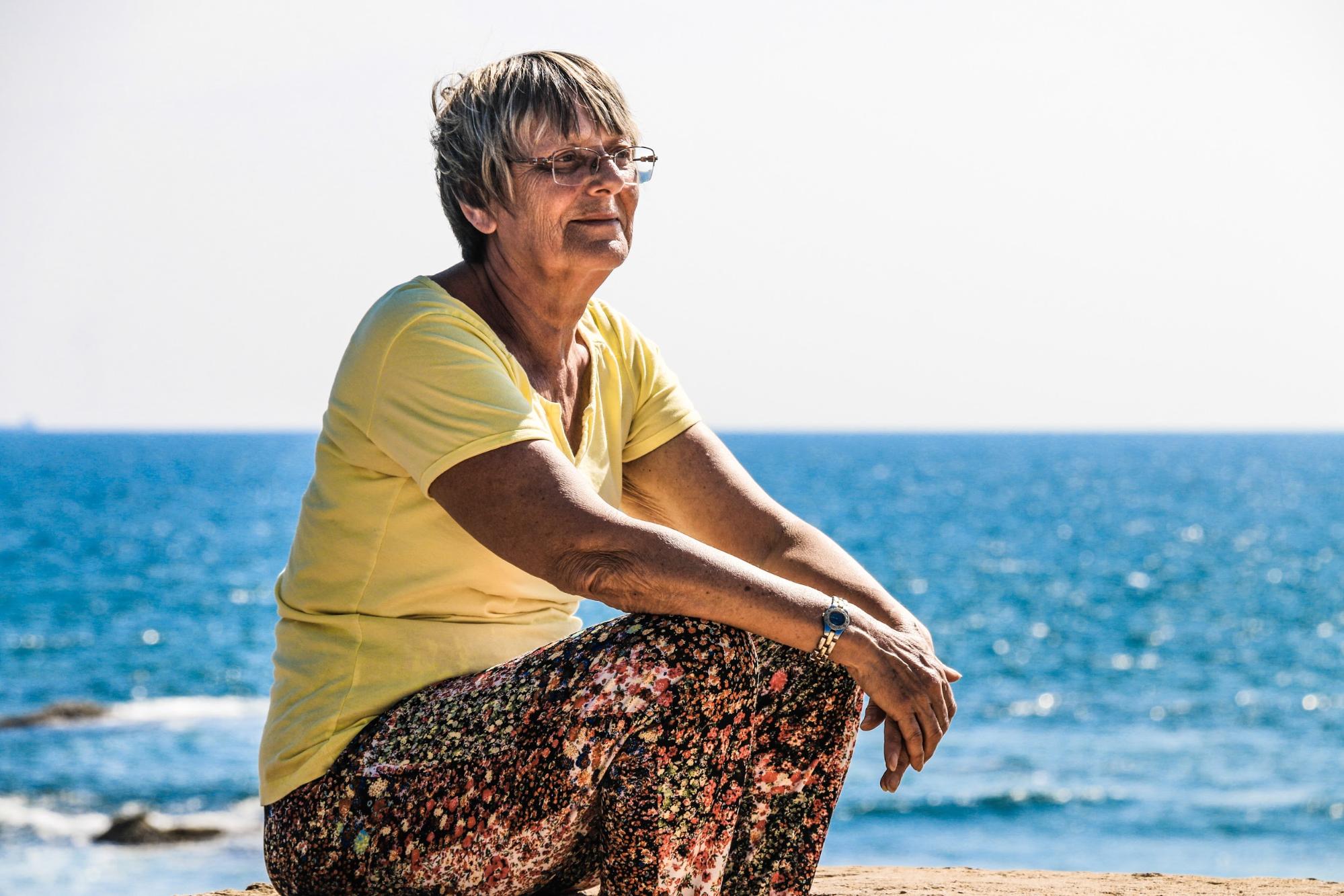 Older woman enjoying sunshine on beach - Early Signs of Dementia - Focus Care