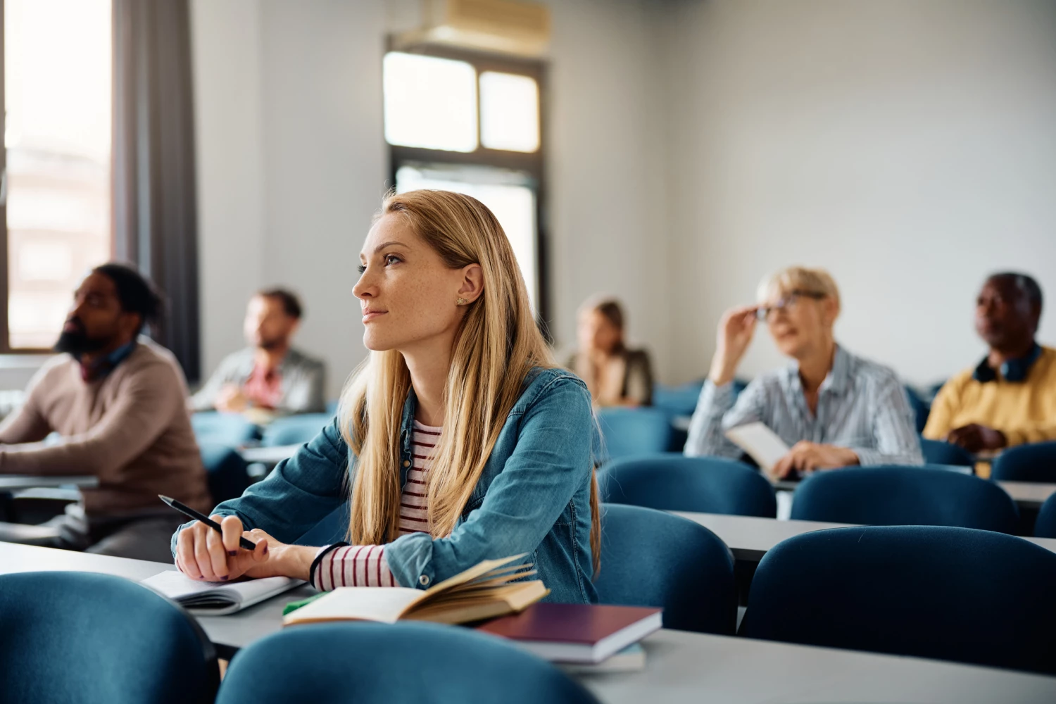 Diverse adult learners engaged in a classroom setting in Australia, highlighting the learning journey of becoming qualified support workers.