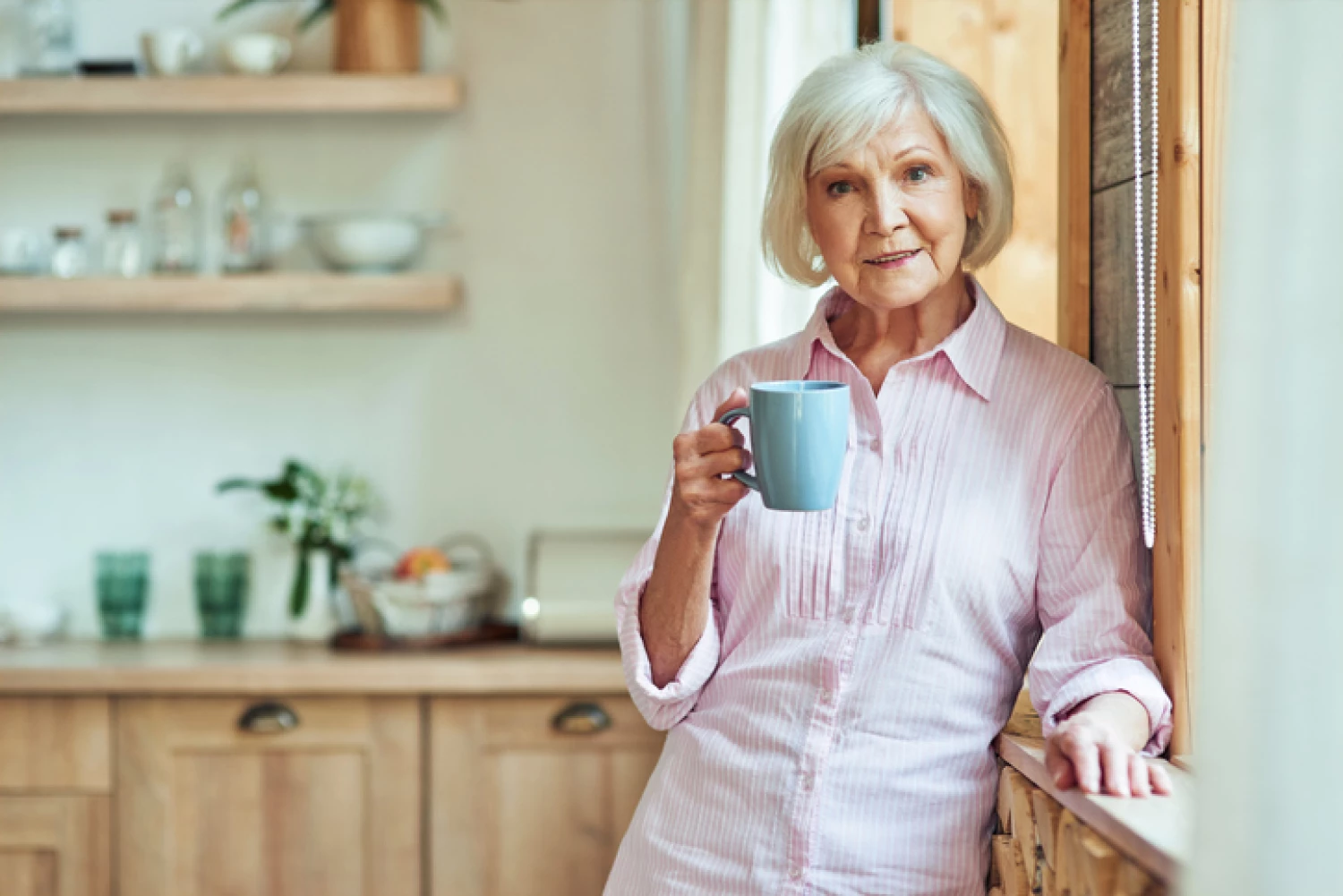 Elderly woman enjoying a cup of coffee in her home, supported by a Home Care Package level 2, helping her live independently.