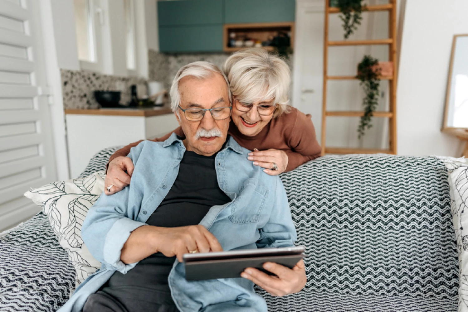 Elderly couple using a tablet to manage their find a home care package provider.