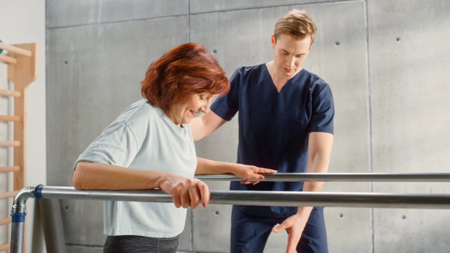 Occupational therapist assisting a middle-aged woman with walking exercises in a rehabilitation setting to enhance mobility.