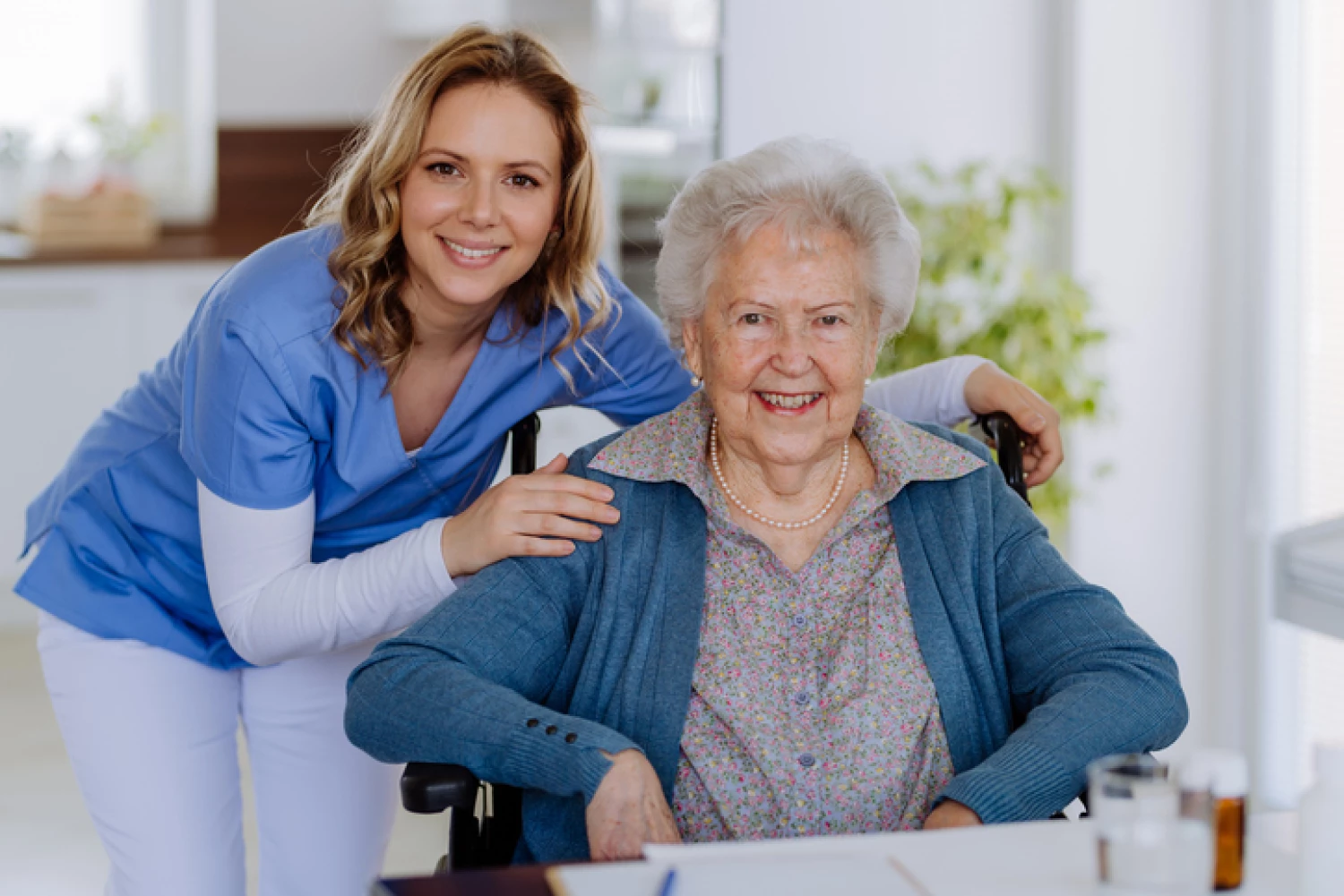 Smiling nurse with an elderly woman in a wheelchair, providing complex nursing care through a government-funded Home Care Package.