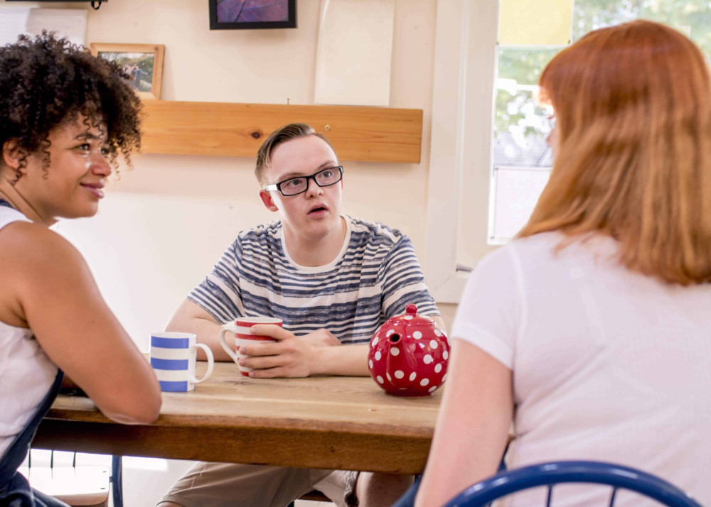 A person with a disability engaged in a discussion with his carers.