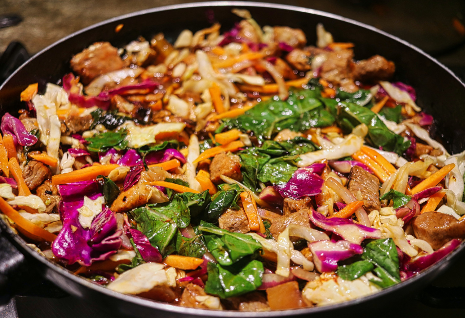 A pot of beef stir fry with carrots, spinach, and red onion - Healthy Food Options for Seniors - Focus Care