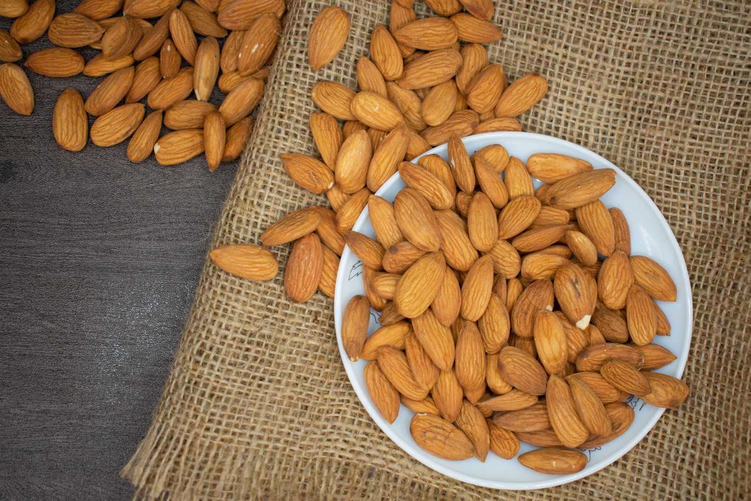 Almonds in a bowl and on the table beside it - Healthy Food Options for Seniors - Focus Care