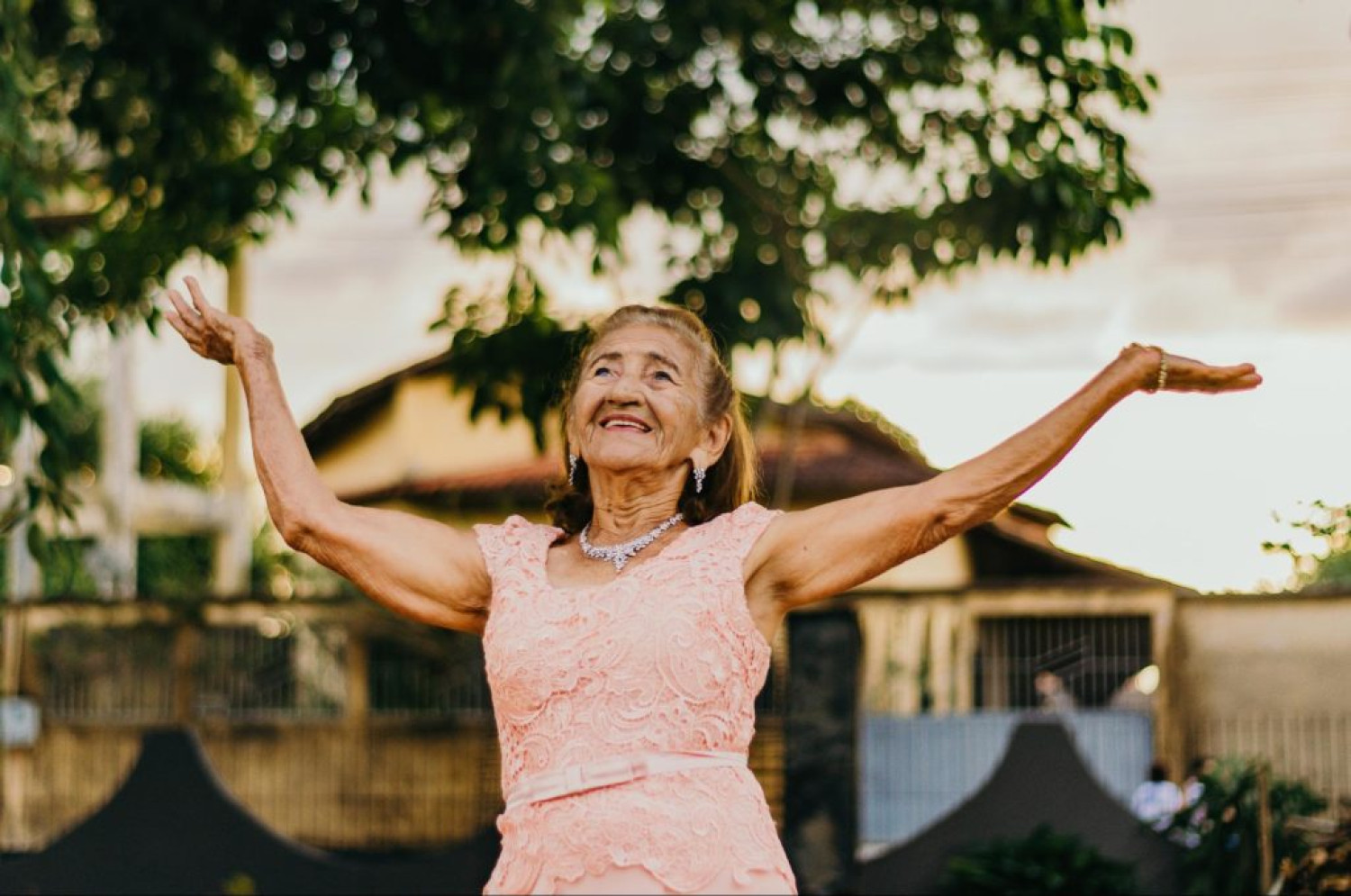 Older lady in pink dress dancing happily - In-home aged care guide - Focus Care.