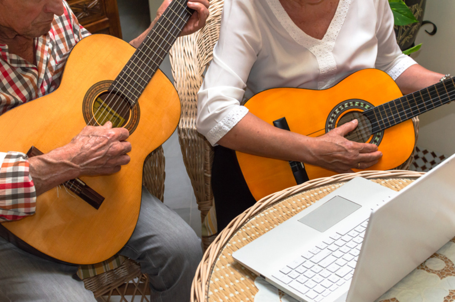Older couple play guitars during a music therapy session for cognitive health.