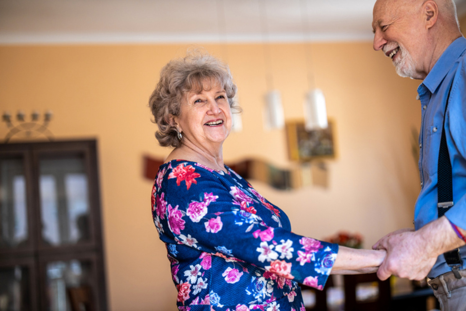 Joyful elderly couple dancing, benefiting from music therapy's social aspects.