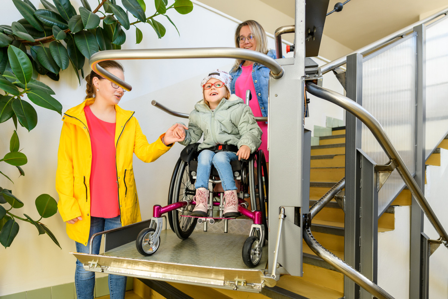 A student using a wheelchair accessing a school building with the aid of an inclined platform lift, exemplifying accessibility in education.