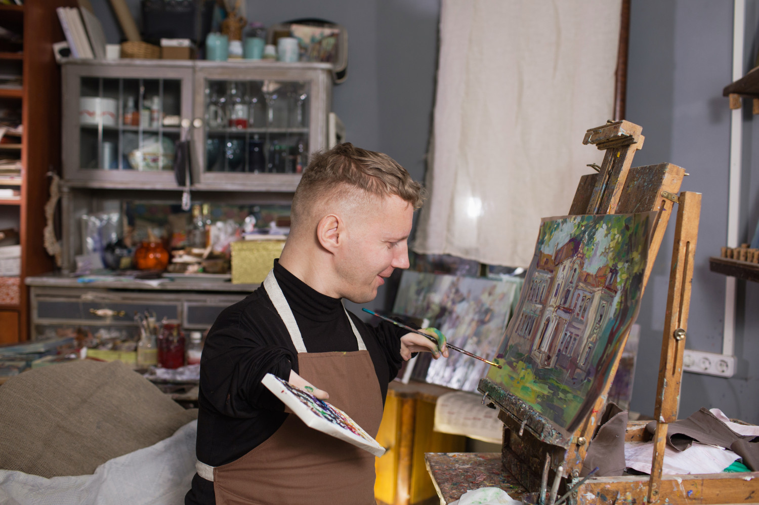 A man with a disability focused on painting a canvas in an art studio, in an art therapy session.
