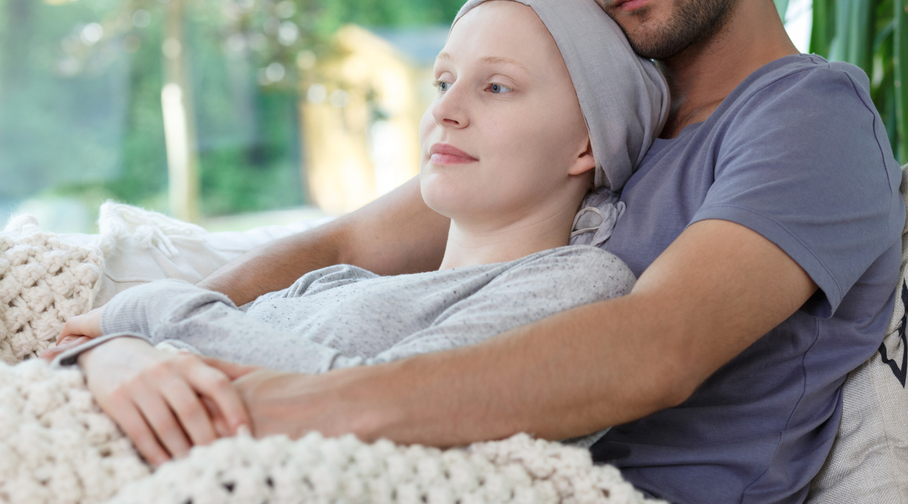 Husband comforting eife with cancer through the challenges with adjusting to palliative care