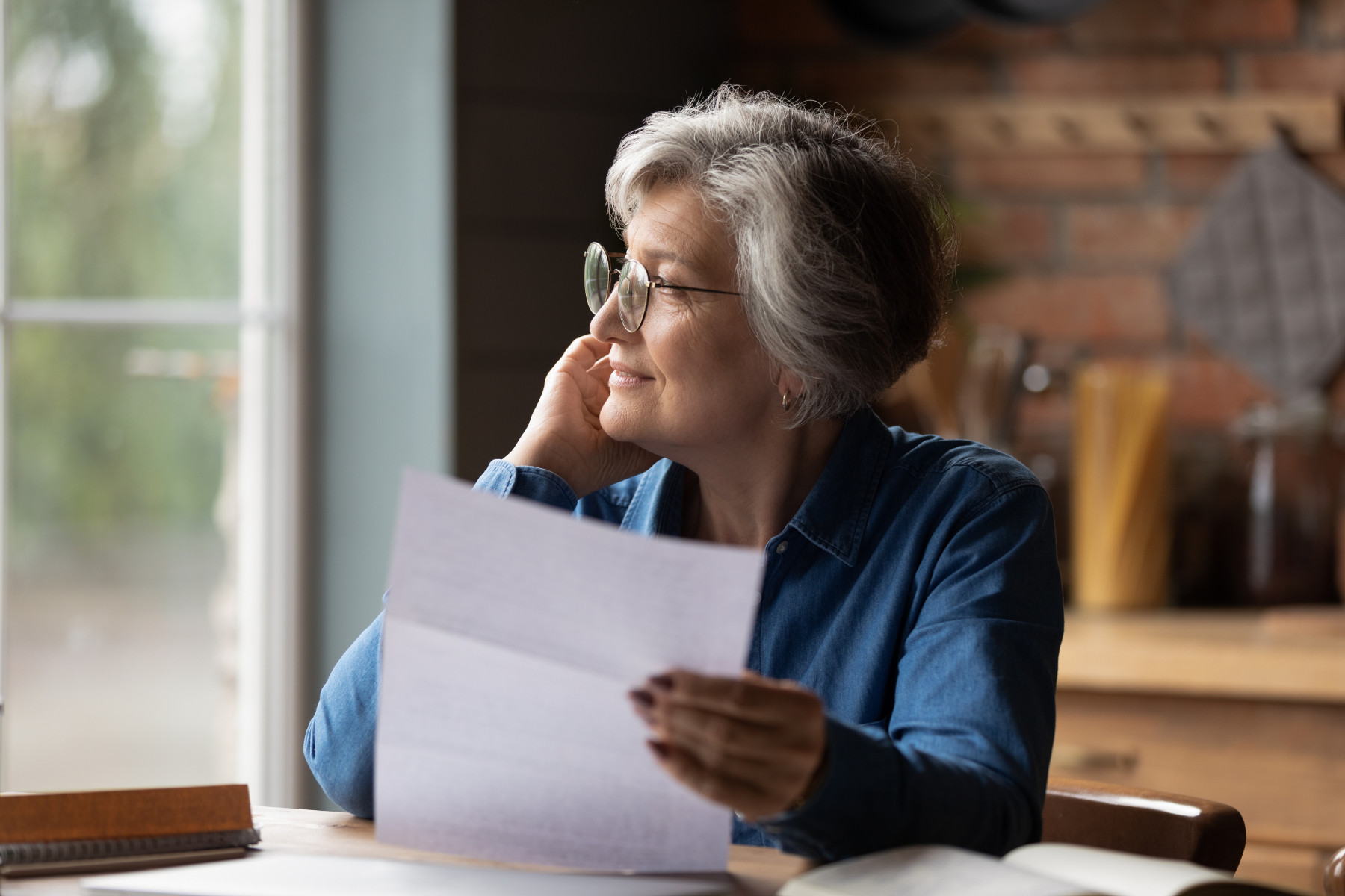 A thoughtful senior woman holding documents, considering a self managed aged care package for home care