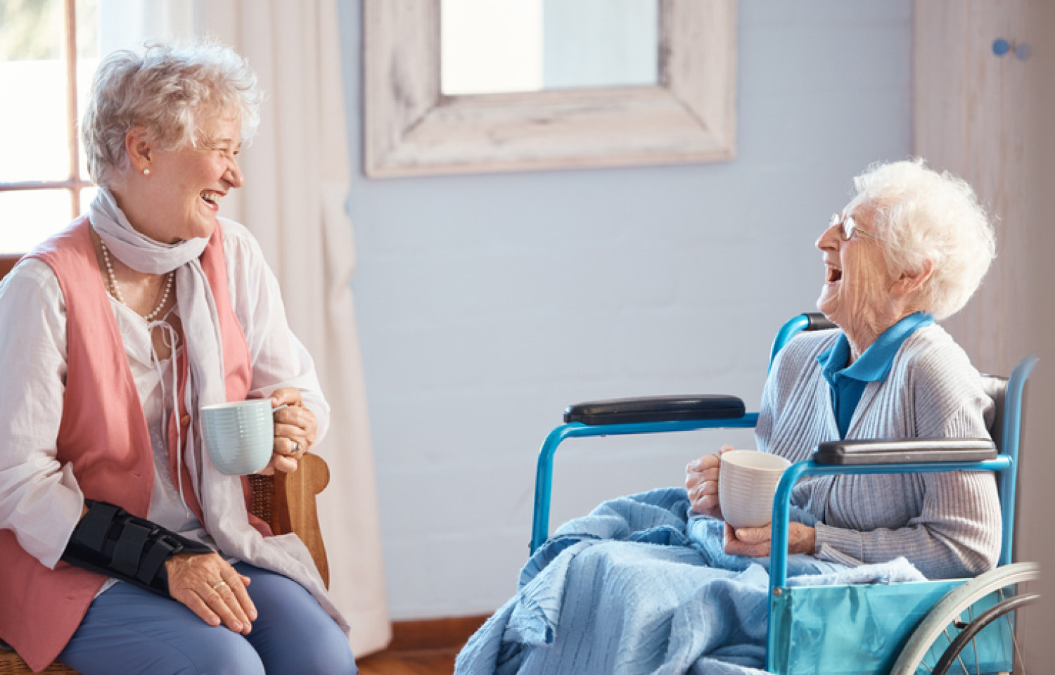A conversation between two senior ladies, one in a wheelchair, showcasing the supportive community aspect of independent living arrangements facilitated by the NDIS.