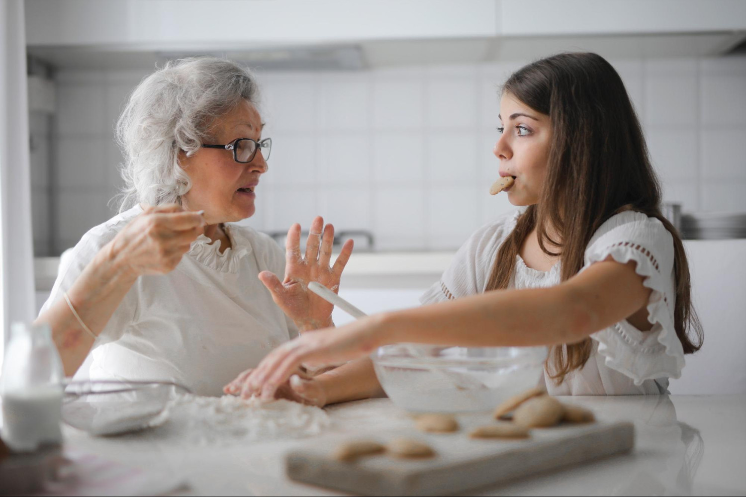 Older woman and teenage girl baking cookies - Dementia early signs - Focus Care
