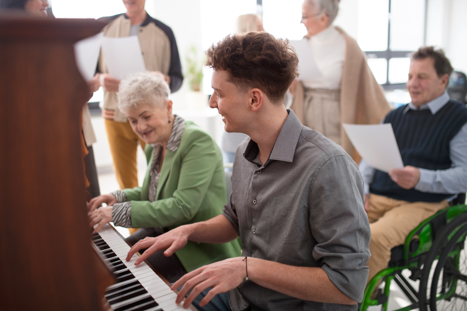 Music therapy group in aged care playing the piano together