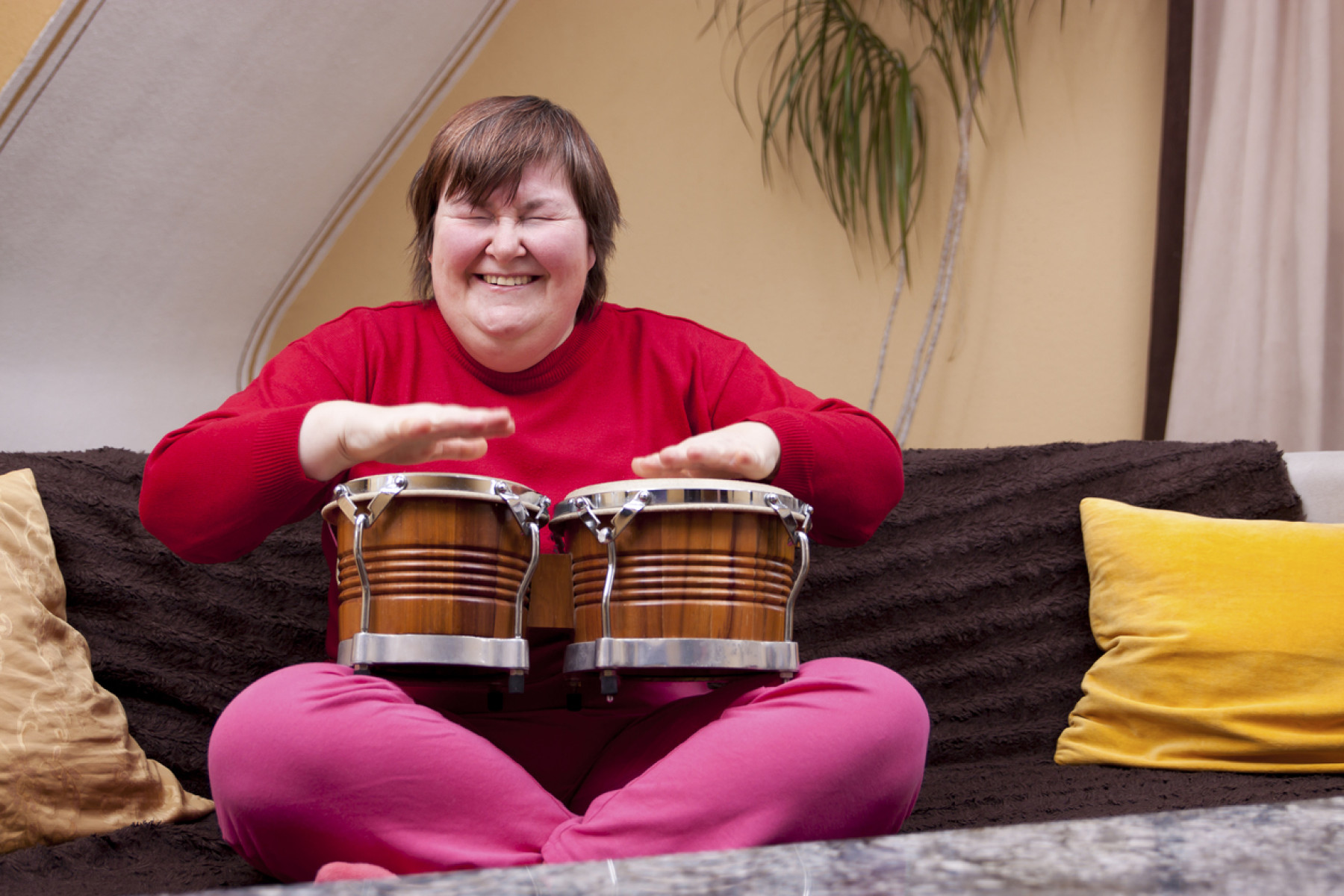 Woman with down syndrome doing Music Therapy with drums